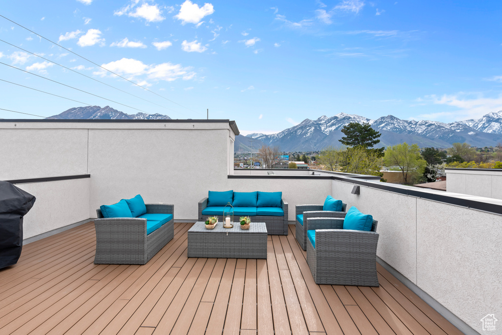 Wooden deck featuring a mountain view and outdoor lounge area