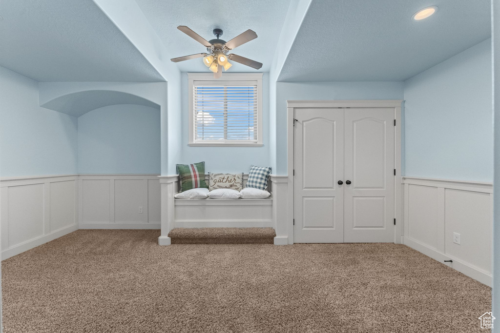 Additional living space featuring light carpet and ceiling fan