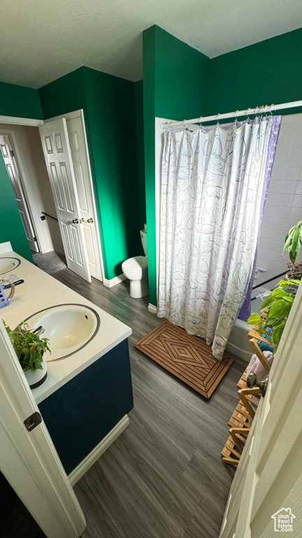 Bathroom with hardwood / wood-style floors, vanity, and shower / bath combo