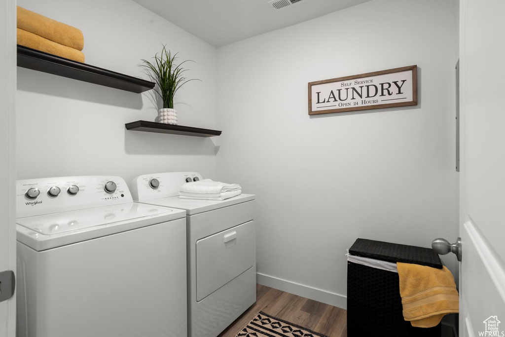 Laundry area featuring dark wood-type flooring and washing machine and clothes dryer