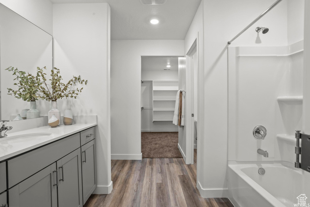 Bathroom with hardwood / wood-style floors, vanity, and tub / shower combination