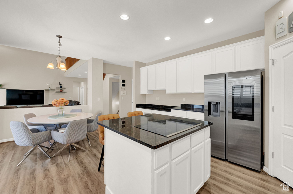 Kitchen featuring a center island, white cabinetry, stainless steel fridge with ice dispenser, light hardwood / wood-style flooring, and black electric stovetop