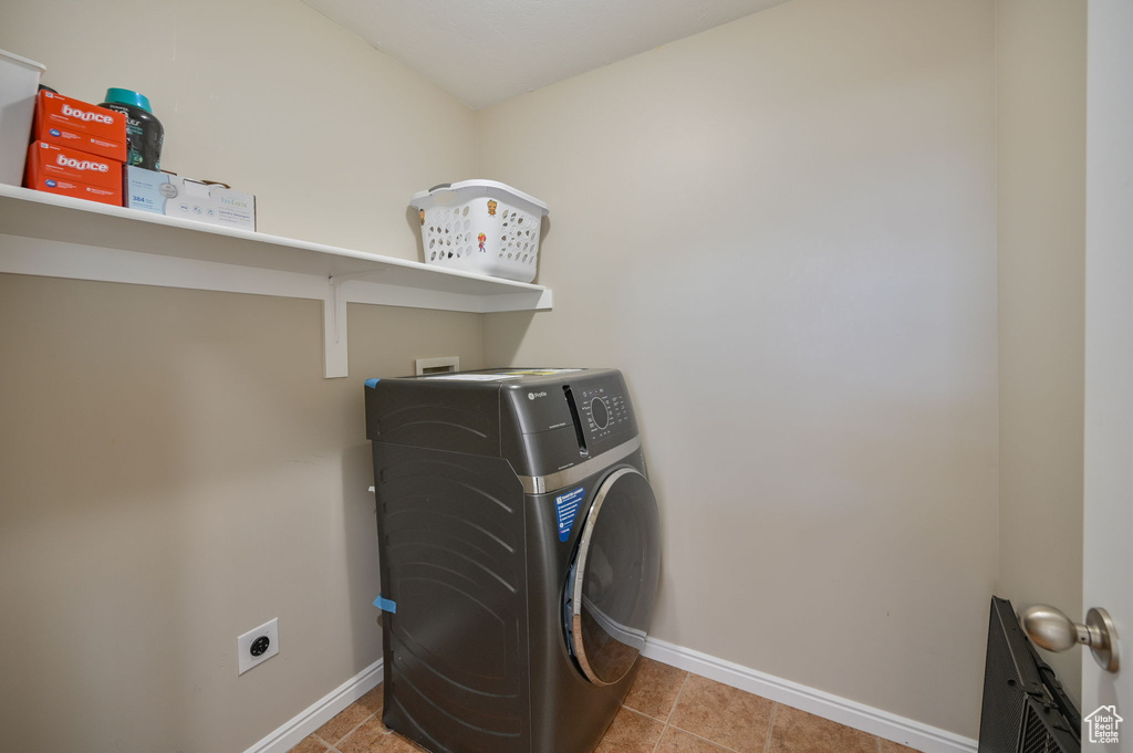 Washroom featuring washer / clothes dryer and light tile floors