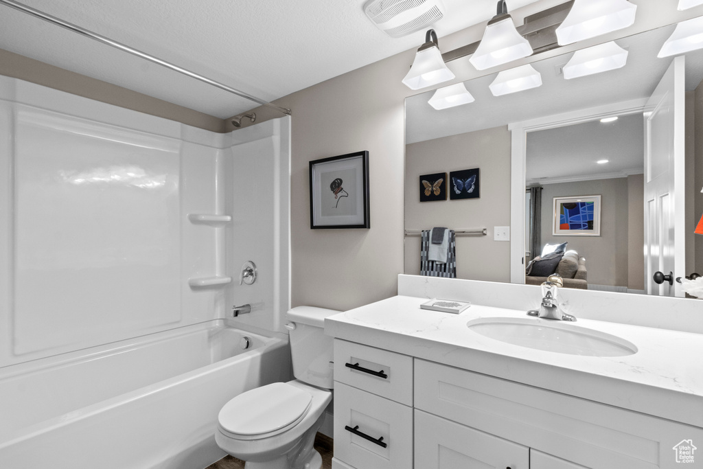 Full bathroom with washtub / shower combination, oversized vanity, crown molding, and toilet