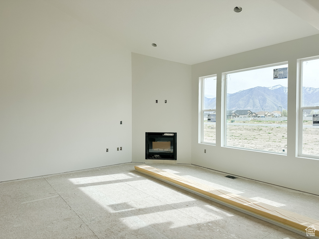 Unfurnished living room featuring plenty of natural light and a mountain view