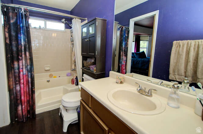 Full bathroom with a wealth of natural light, shower / tub combo, toilet, and vanity