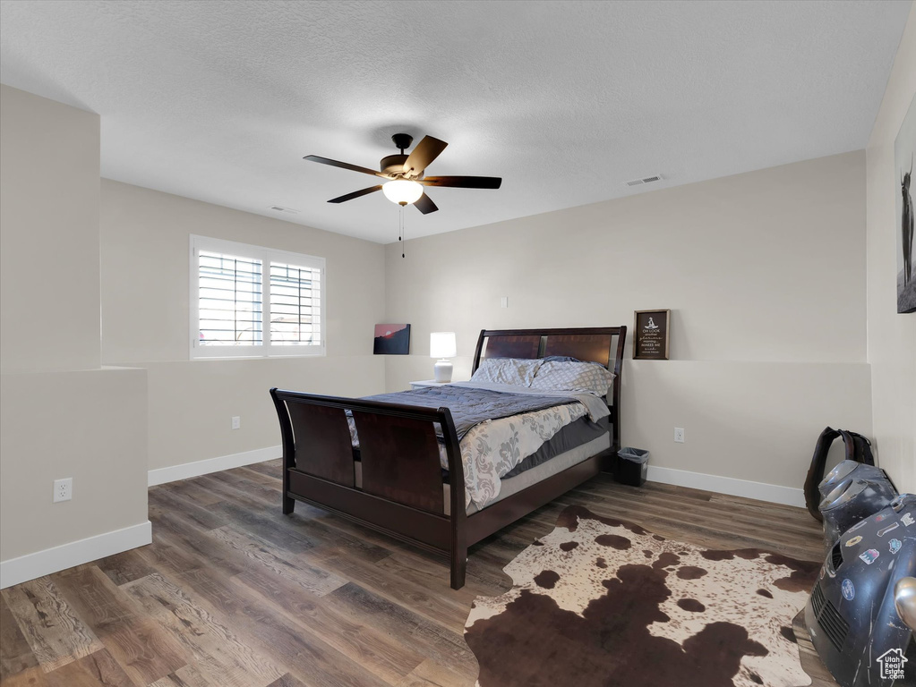 Bedroom with dark hardwood / wood-style floors and ceiling fan