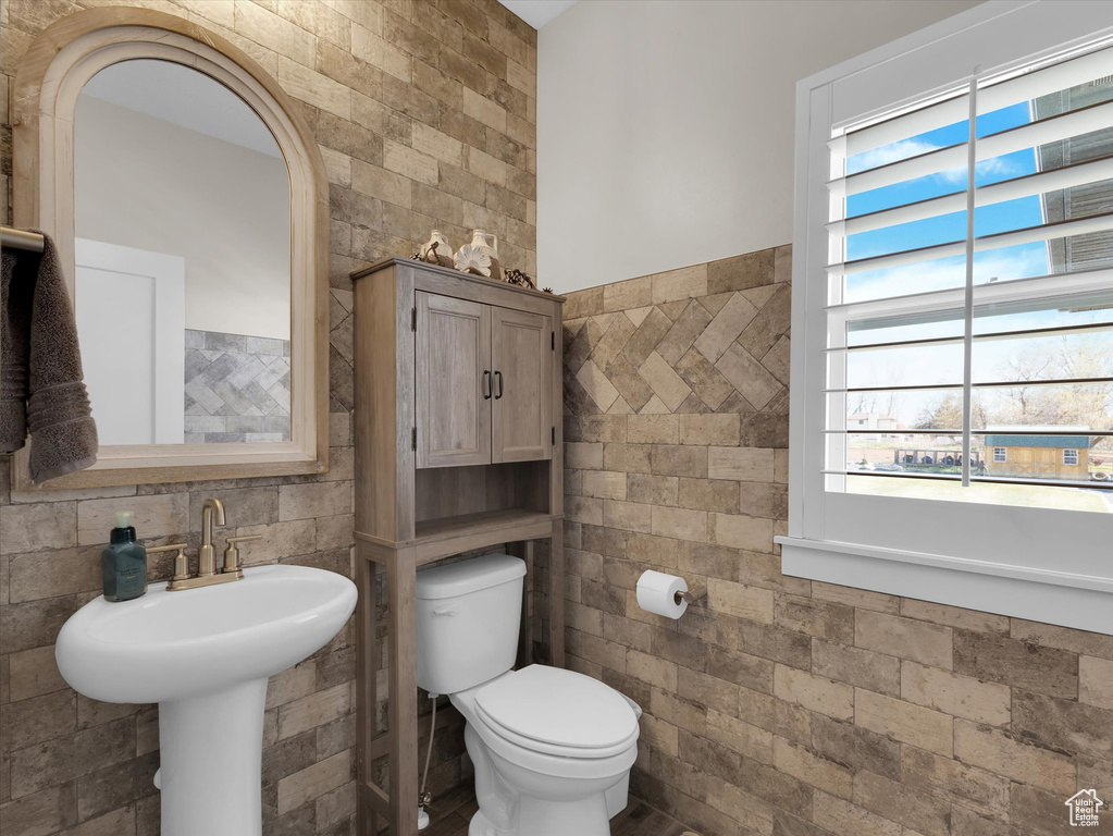 Bathroom with tile walls, tasteful backsplash, and toilet