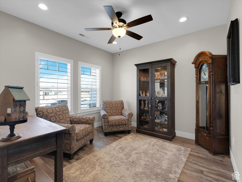 Living area with dark wood-type flooring and ceiling fan