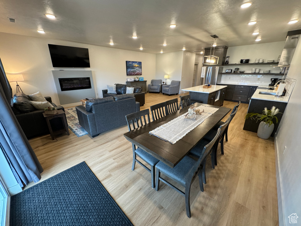 Dining space with sink and light wood-type flooring