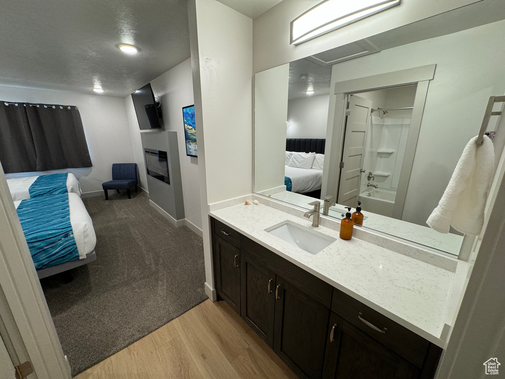 Bathroom featuring shower / bath combination, hardwood / wood-style floors, and large vanity