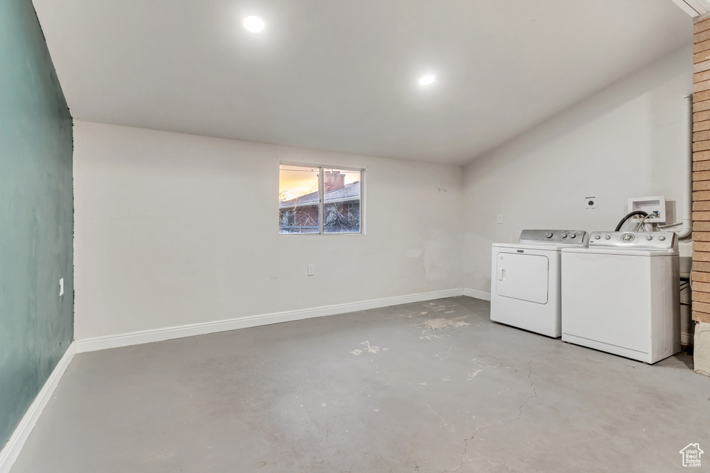 Laundry room featuring brick wall, washer hookup, and washer and clothes dryer
