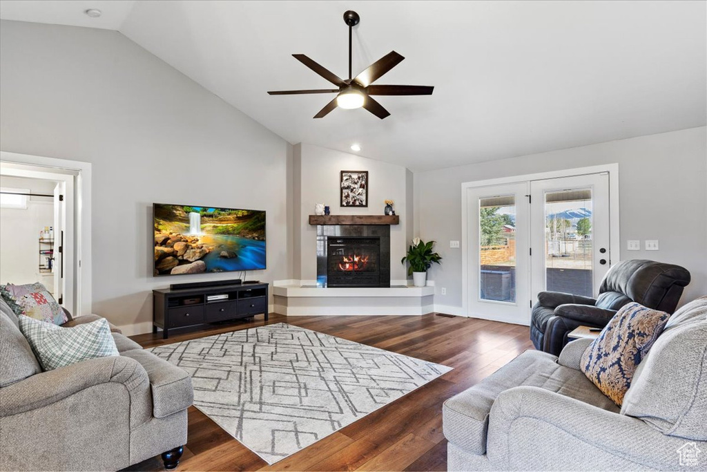 Living room with dark hardwood / wood-style floors, high vaulted ceiling, and ceiling fan