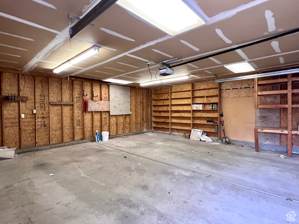 Garage featuring wooden walls and a garage door opener