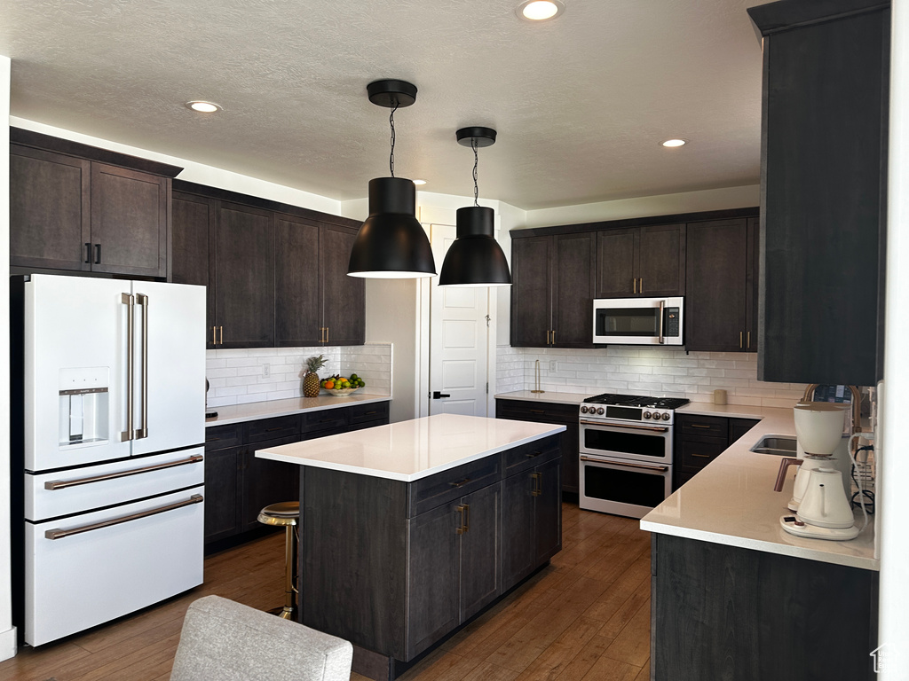 Kitchen featuring a center island, tasteful backsplash, decorative light fixtures, and premium appliances
