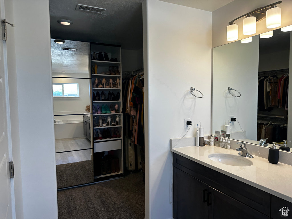 Bathroom featuring vanity and a textured ceiling