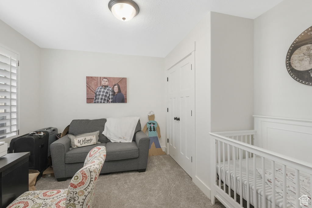 Bedroom with a nursery area and light carpet