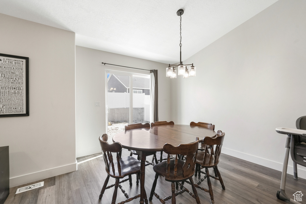 Dining area featuring dark hardwood / wood-style flooring and a notable chandelier