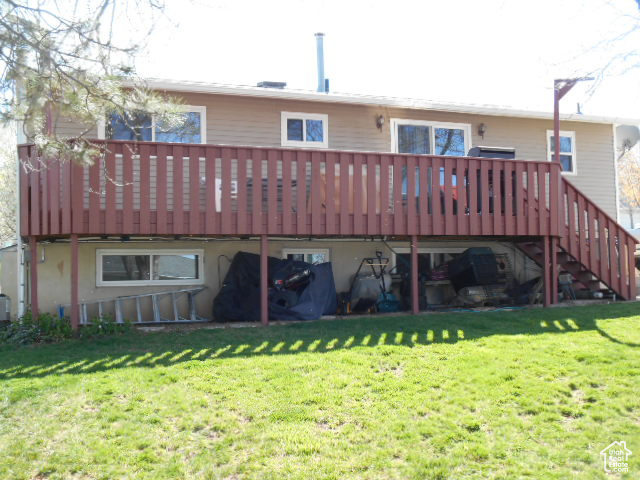 Back of property with a deck and a lawn