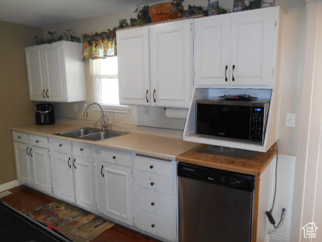Kitchen with stainless steel dishwasher, sink, built in microwave, and white cabinets