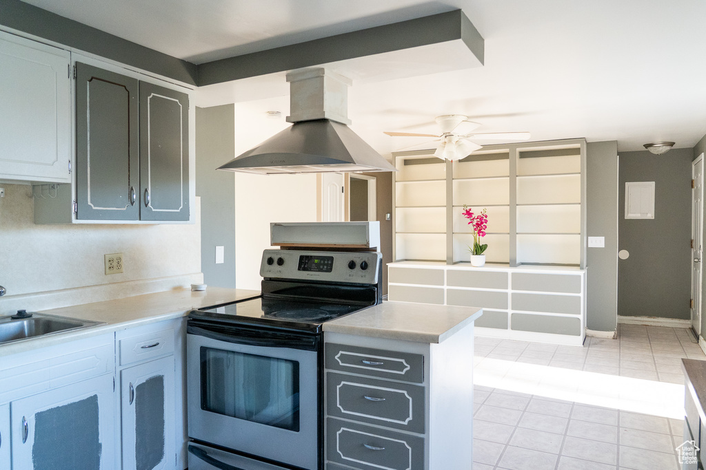 Kitchen with ceiling fan, island range hood, electric range, sink, and light tile floors