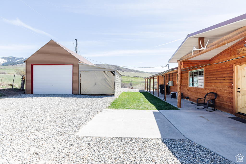 View of yard featuring a mountain view, an outdoor structure, and a garage