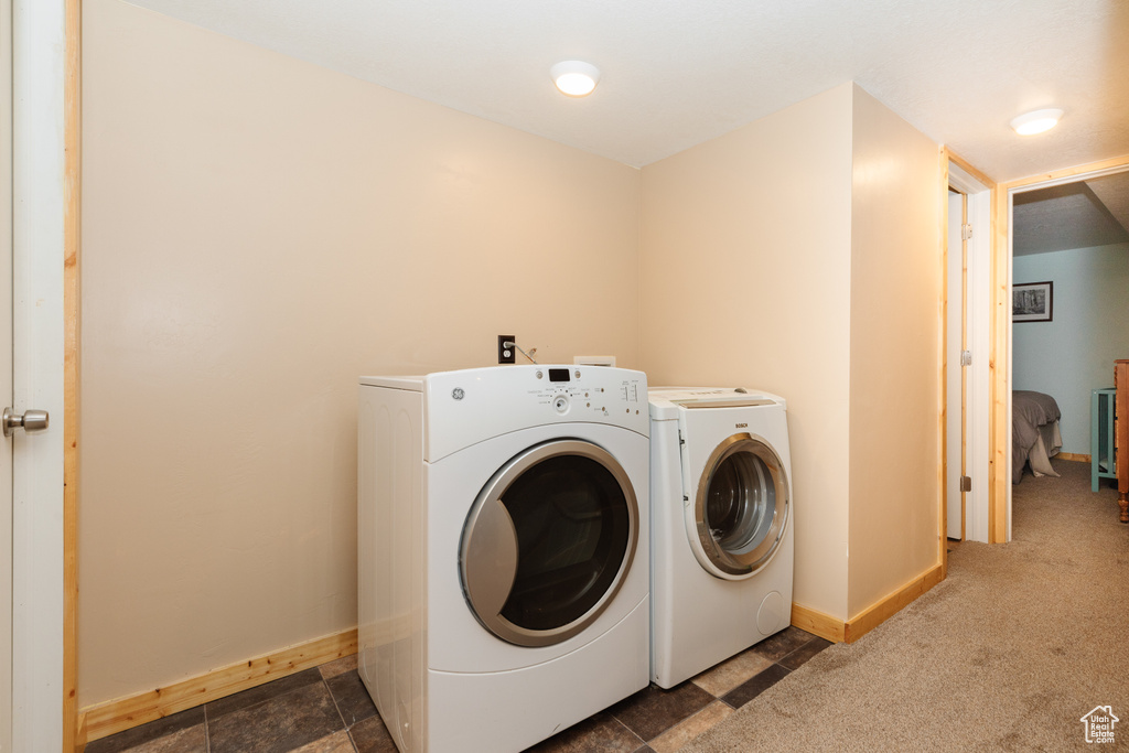 Laundry area with dark carpet and washer and clothes dryer