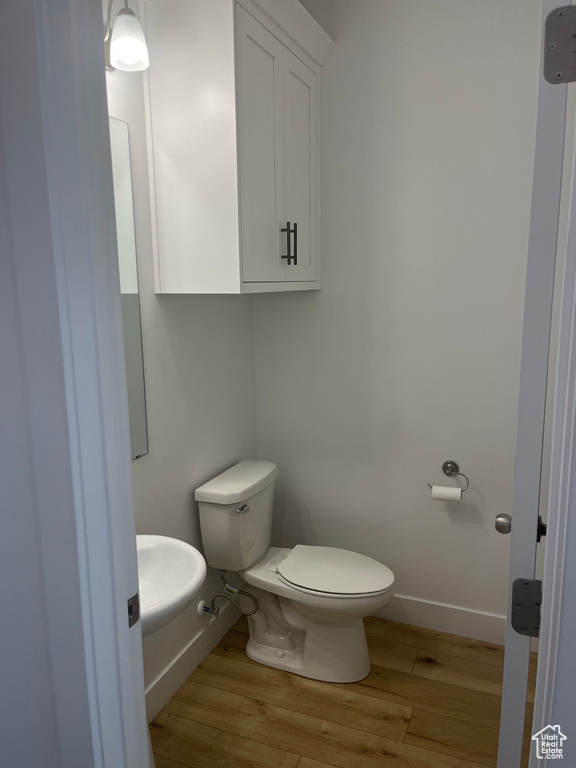 Bathroom featuring hardwood / wood-style floors, sink, and toilet