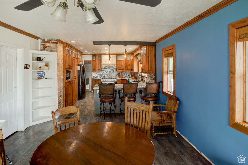 Dining room featuring ornamental molding, dark hardwood / wood-style flooring, and ceiling fan