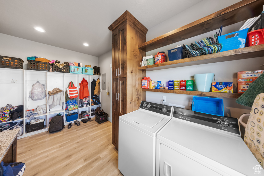Clothes washing area featuring light hardwood / wood-style flooring and washer and clothes dryer