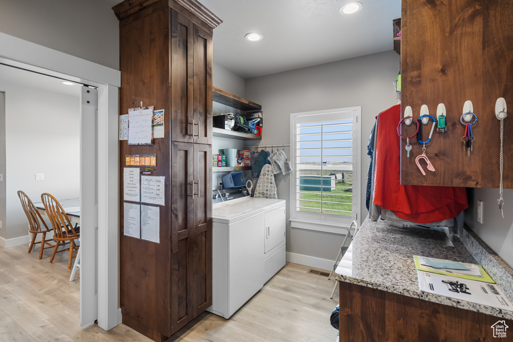 Laundry room featuring light hardwood / wood-style floors and washing machine and clothes dryer