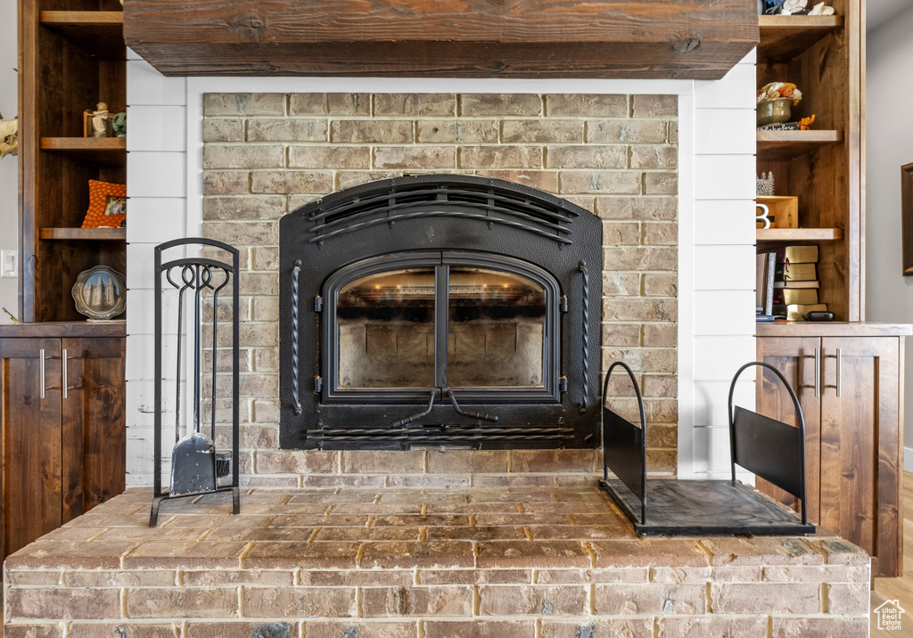 Room details featuring beam ceiling, a wood stove, and a fireplace