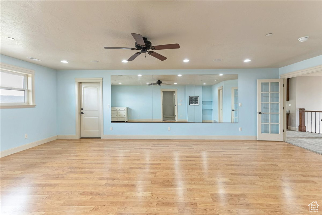Unfurnished living room with ceiling fan and light wood-type flooring