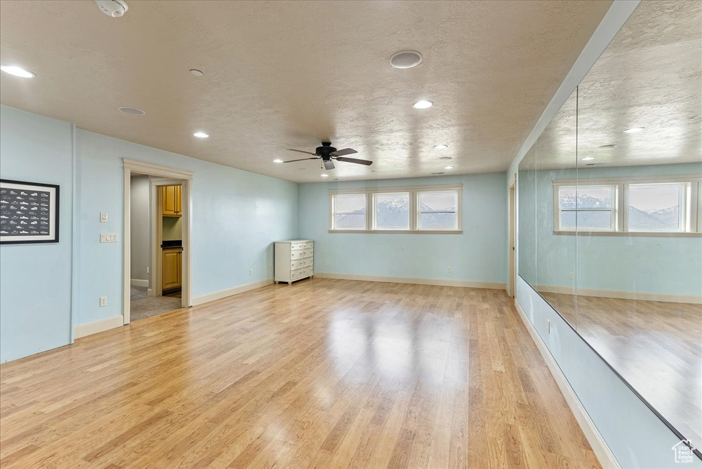 Empty room featuring a healthy amount of sunlight, ceiling fan, and light hardwood / wood-style floors