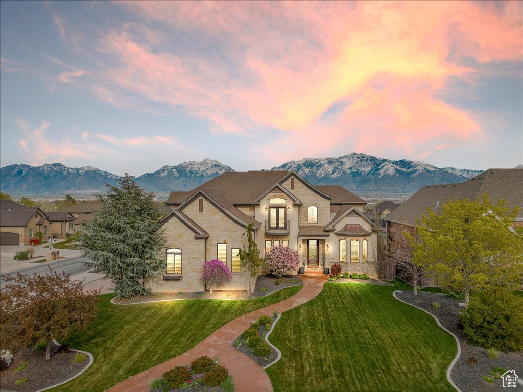 French provincial home with a mountain view, a yard, and a garage