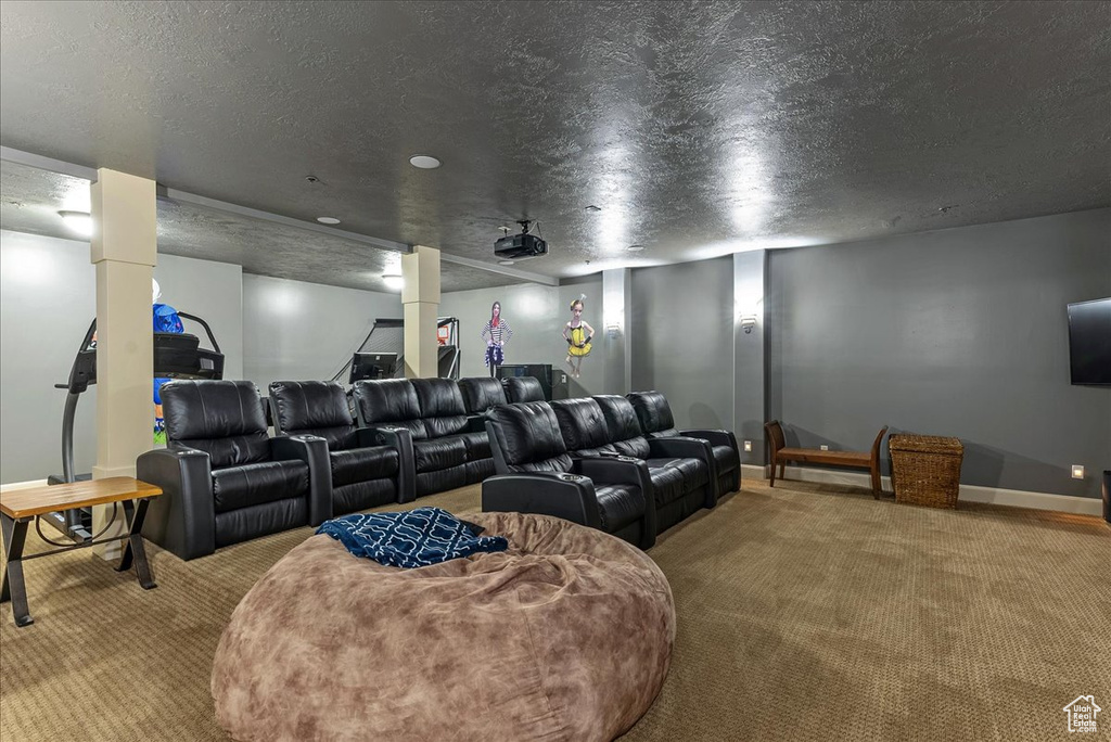Home theater room with light carpet and a textured ceiling