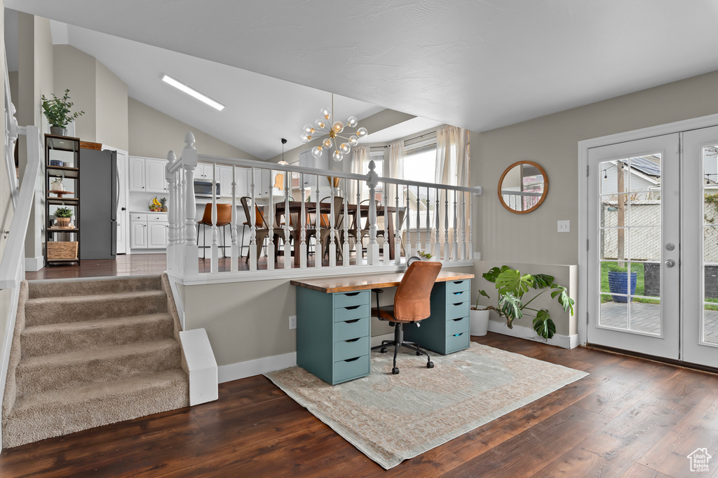 Office space with lofted ceiling, french doors, dark hardwood / wood-style flooring, and a notable chandelier
