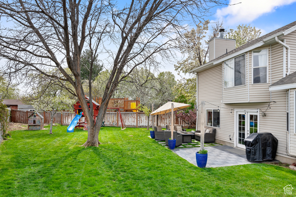 View of yard with a playground, an outdoor hangout area, and a patio area