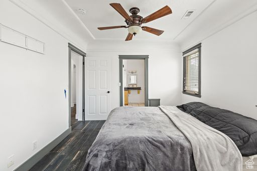 Bedroom featuring dark hardwood / wood-style floors, ceiling fan, and connected bathroom