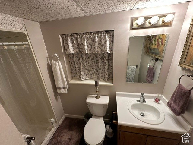 Bathroom featuring vanity, toilet, and a paneled ceiling
