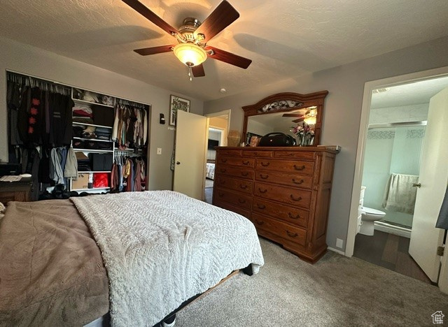 Carpeted bedroom featuring a closet, ceiling fan, and ensuite bath