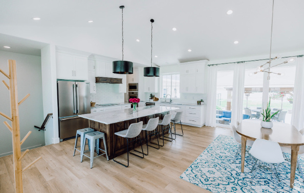 Kitchen featuring a center island, decorative light fixtures, light hardwood / wood-style flooring, backsplash, and stainless steel appliances