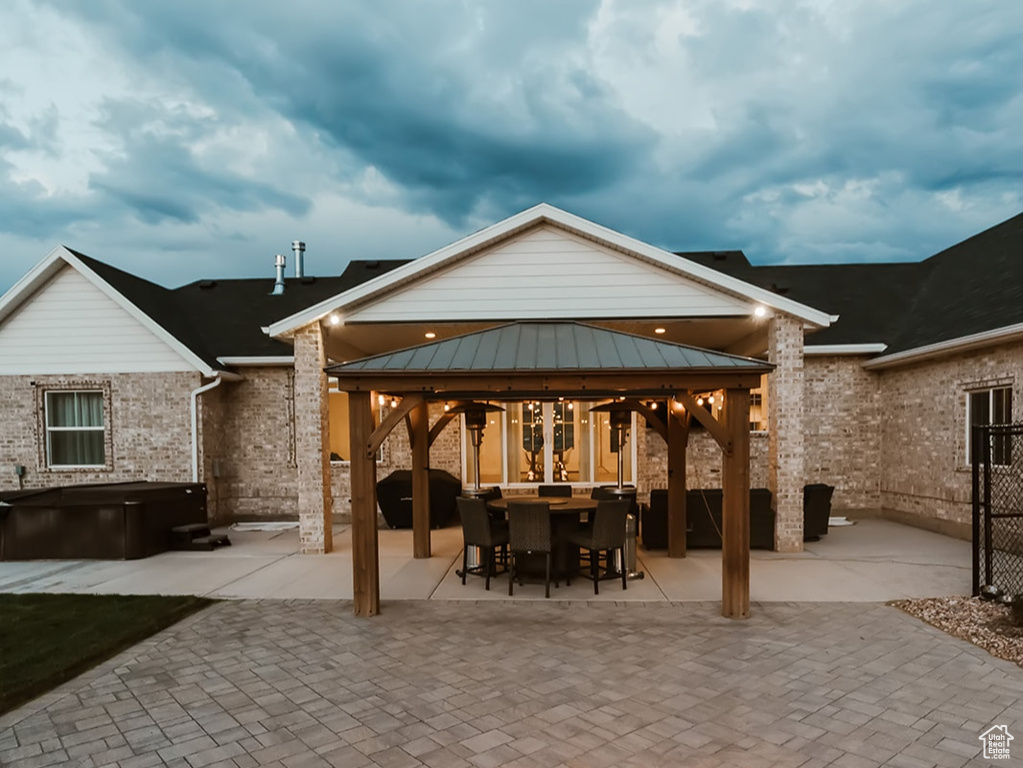 Exterior space with a gazebo, a fire pit, and a patio area