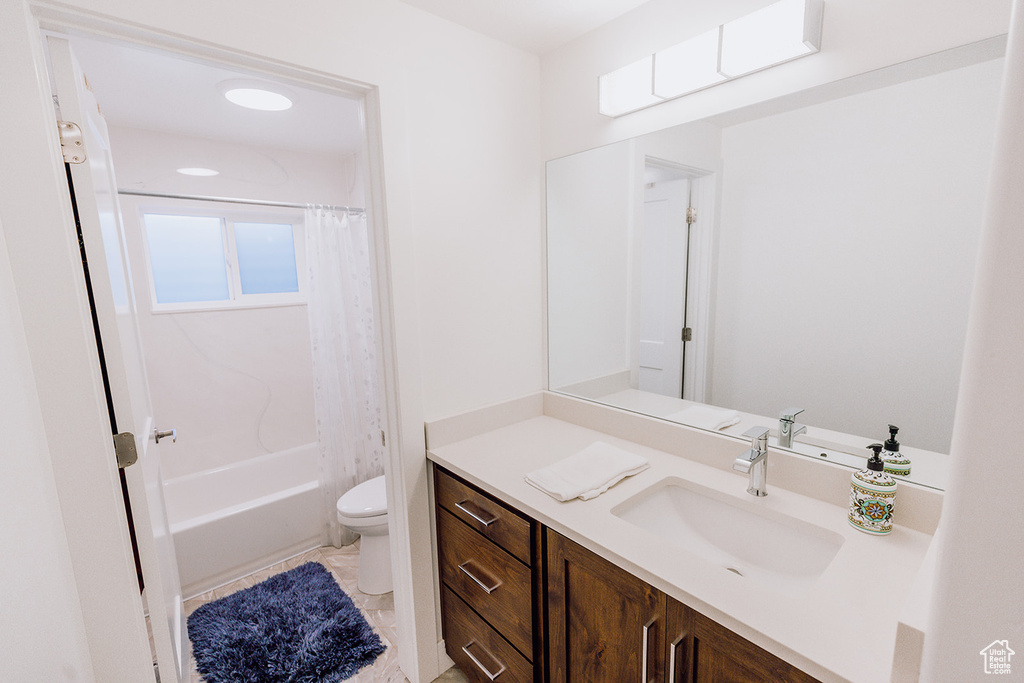 Full bathroom with vanity, tile floors, toilet, and shower / bath combination with curtain