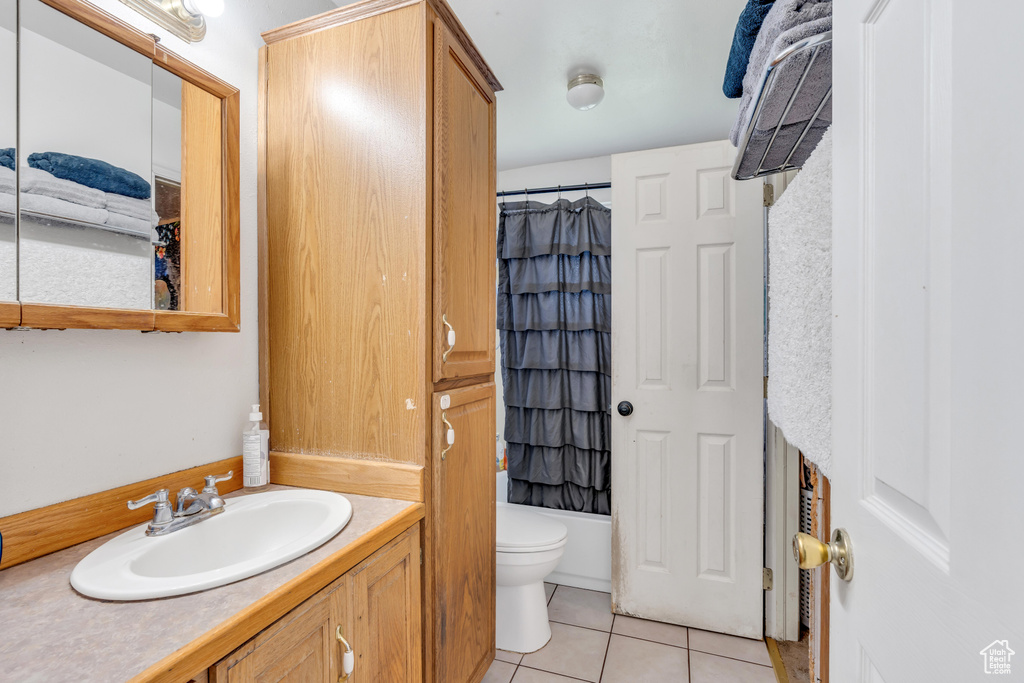 Full bathroom with shower / tub combo with curtain, vanity, tile floors, and toilet