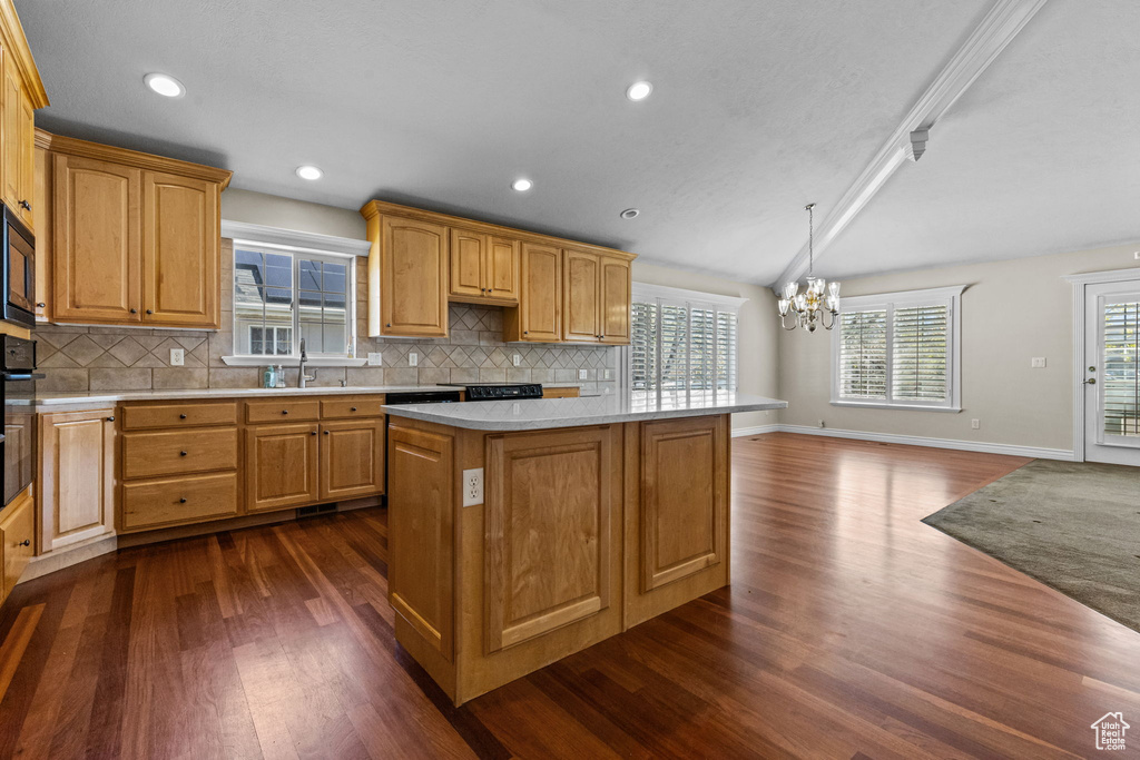 Kitchen with a wealth of natural light, tasteful backsplash, and dark wood-type flooring