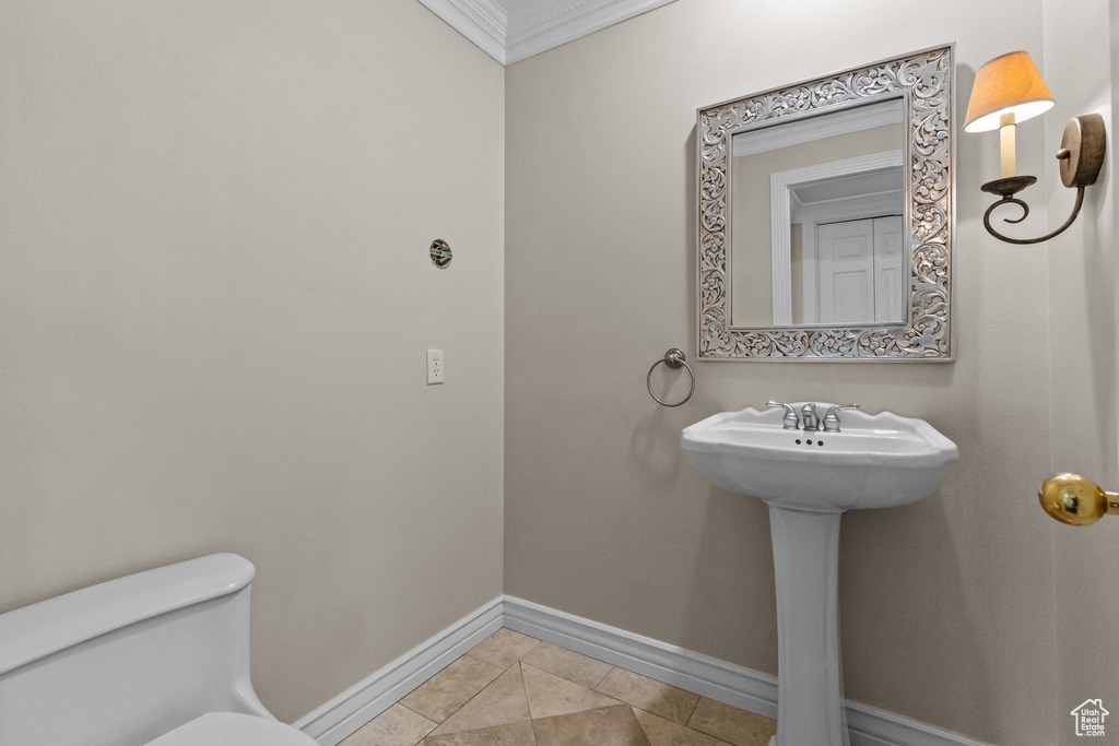 Bathroom featuring crown molding, toilet, and tile flooring
