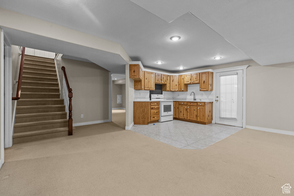 Kitchen featuring light colored carpet, sink, and white electric range oven
