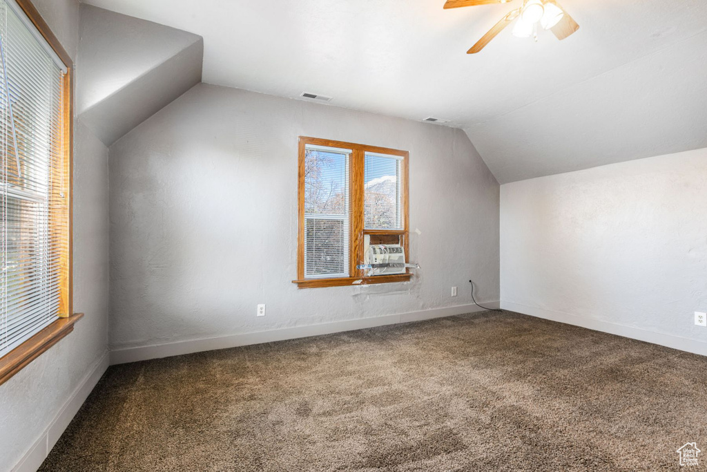 Bonus room featuring vaulted ceiling, ceiling fan, and dark colored carpet