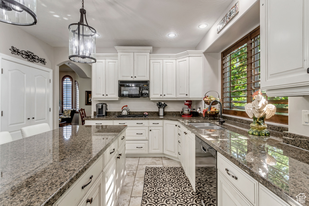 Kitchen featuring sink, light tile flooring, white cabinetry, black appliances, and dark stone countertops